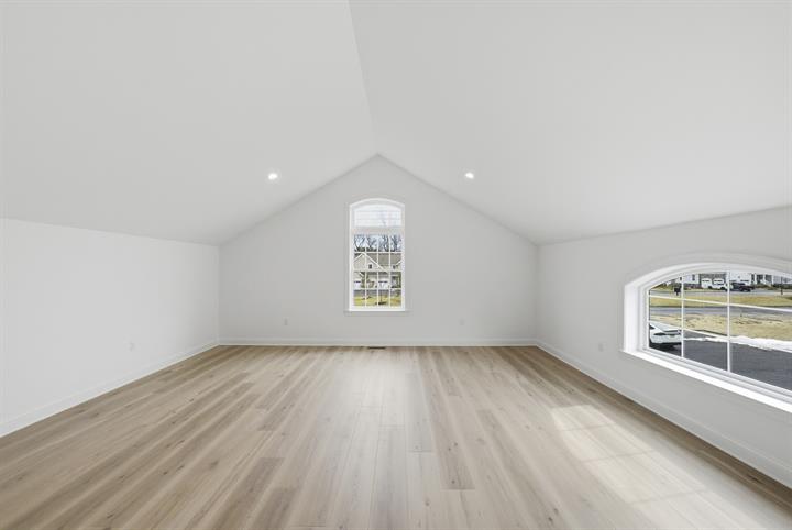 Upper-level bonus room with arched window