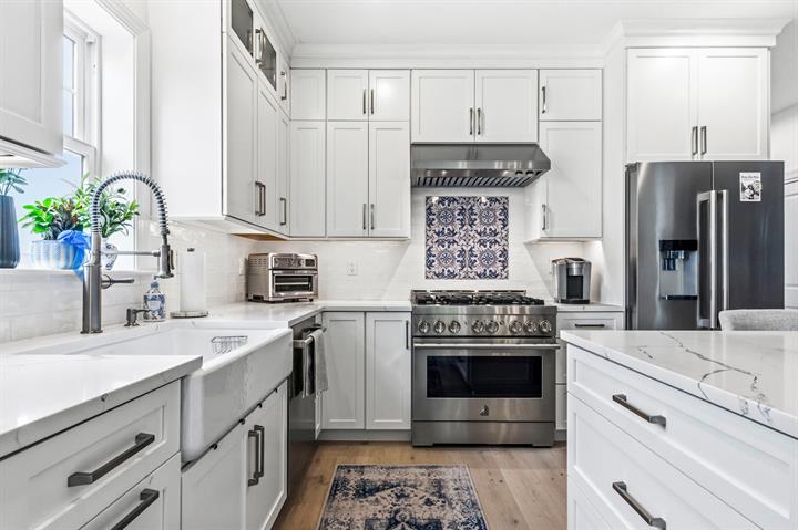 Farmhouse sink & pro-style range: With a custom tile backsplash