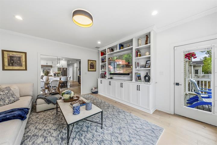 Family room with built-in shelving and a door to the deck